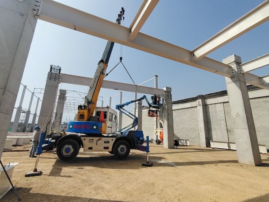 Montaje de estructura metálica con grúa en una nave industrial