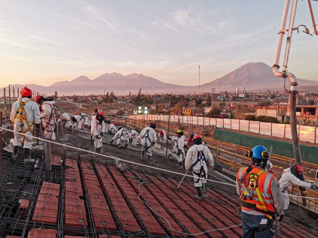 Cuadrilla vaciando una losa de concreto con los volcanes de Arequipa al fondo